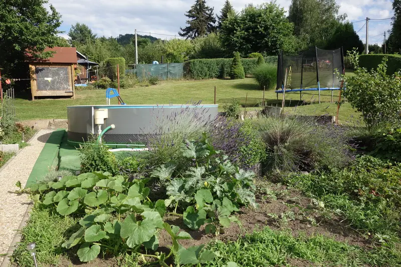Zahrada s bazénem a trampolínou
